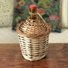 Dame-jeanne bouteille en verre ambré de 2 L Viresa dans son écrin en osier vintage par Hello Broc brocante en ligne