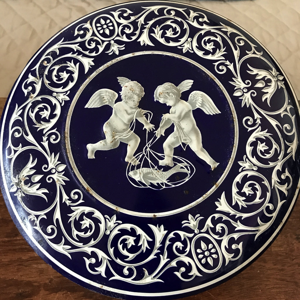 Boîte ronde en métal bleu embossé décoré d'anges blancs