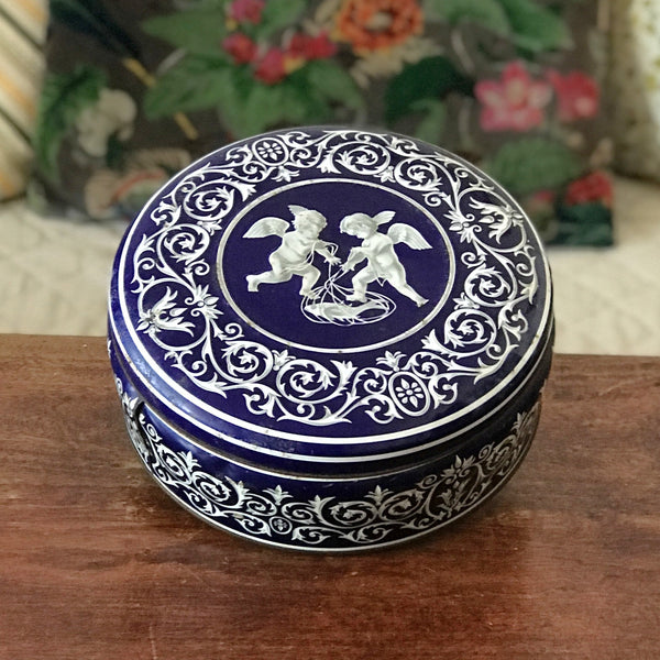 Boîte ronde en métal bleu embossé décoré d'anges blancs par Hello Broc brocante en ligne