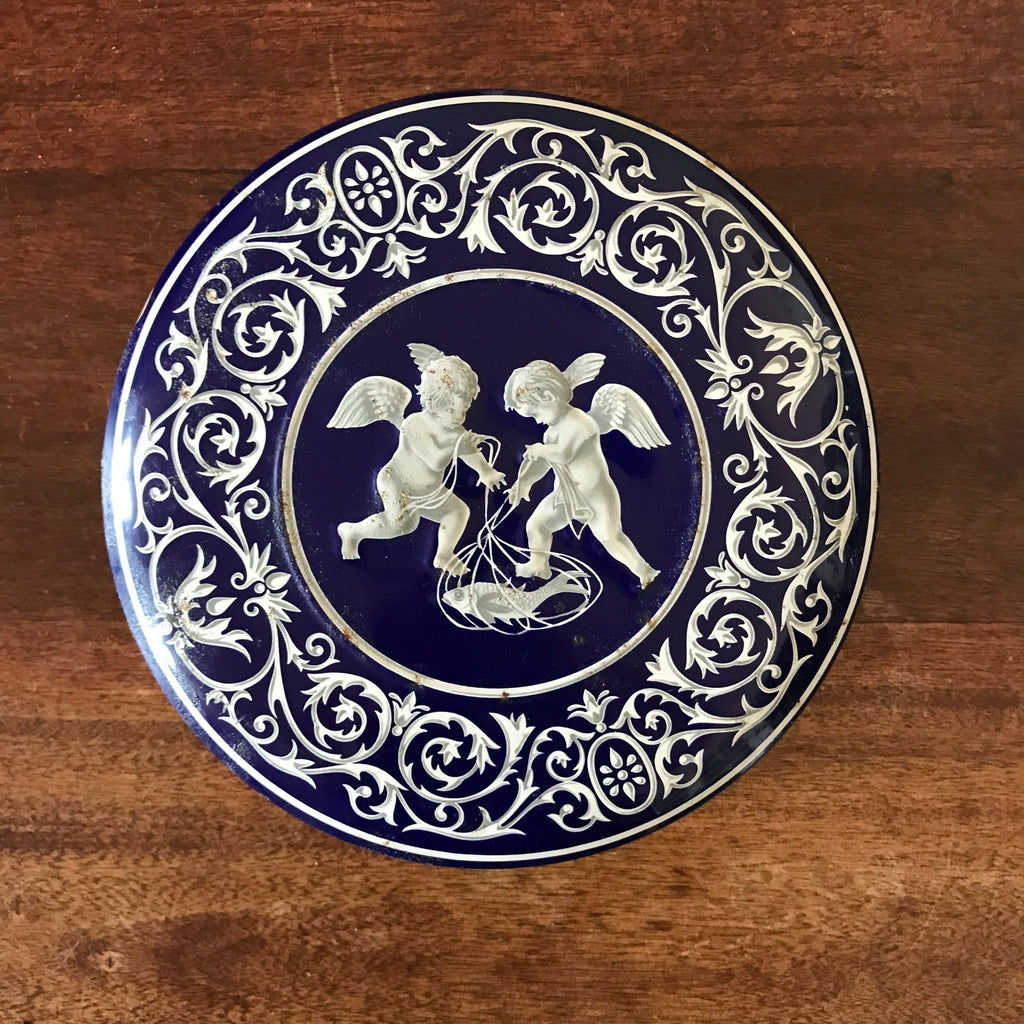 Boîte ronde en métal bleu embossé décoré d'anges blancs
