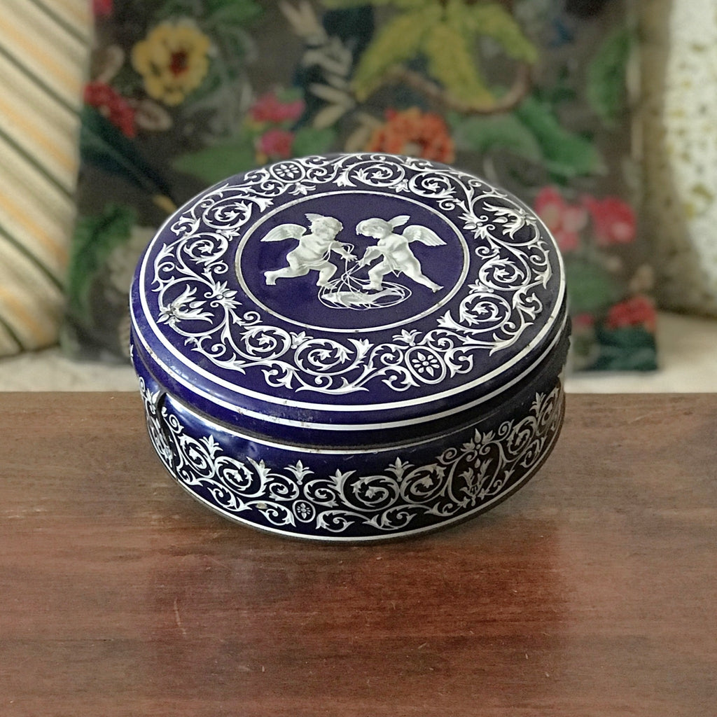 Boîte ronde en métal bleu embossé décoré d'anges blancs par Hello Broc brocante en ligne
