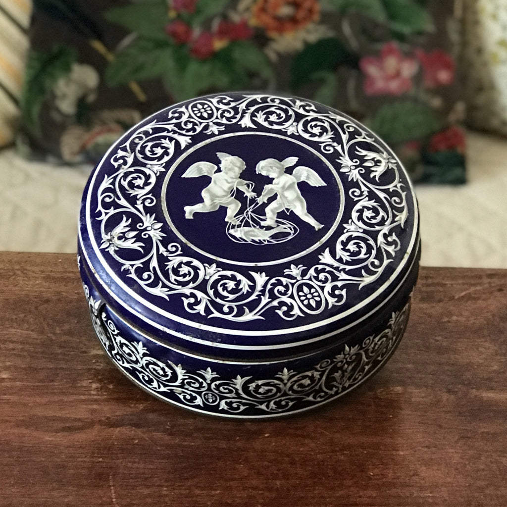 Boîte ronde en métal bleu embossé décoré d'anges blancs par Hello Broc brocante en ligne
