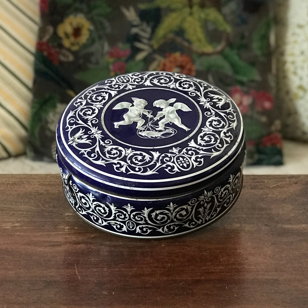 Boîte ronde en métal bleu embossé décoré d'anges blancs par Hello Broc brocante en ligne