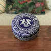 Boîte ronde en métal bleu embossé décoré d'anges blancs par Hello Broc brocante en ligne