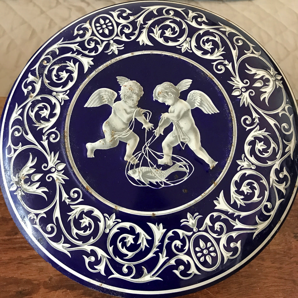 Boîte ronde en métal bleu embossé décoré d'anges blancs par Hello Broc brocante en ligne