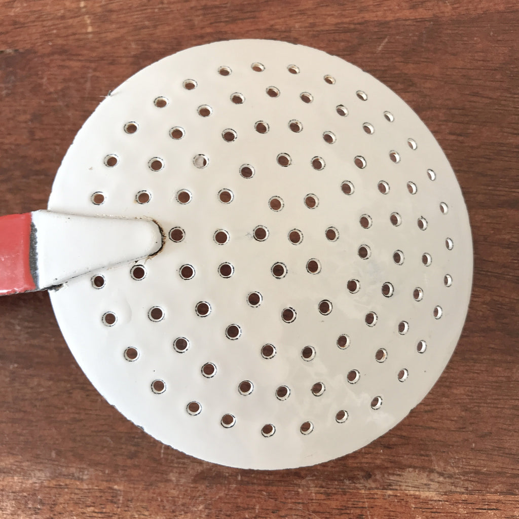 Ecumoire ancienne en métal émaillé bicolore rouge et blanc par Hello Broc brocante en ligne